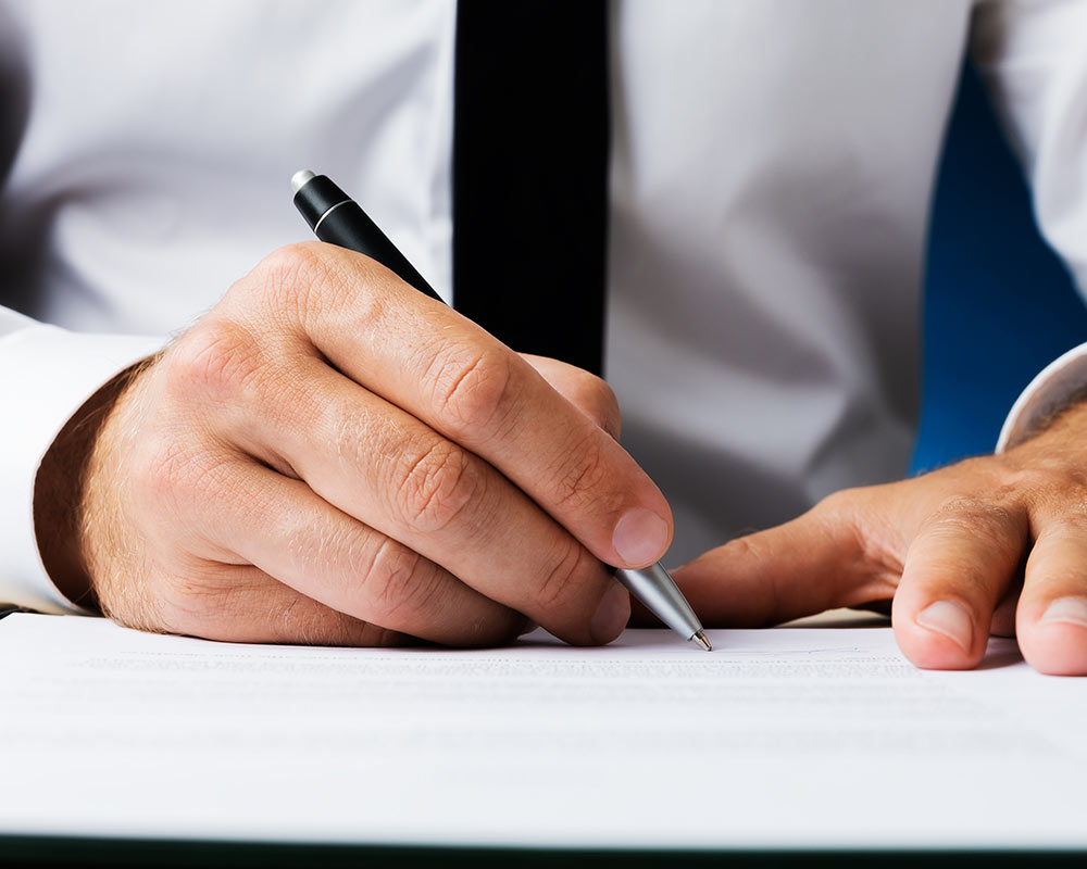 Man signing document with pen