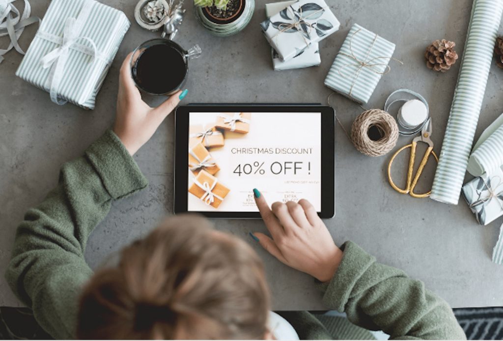 Woman scrolling on an iPad looking for holiday sales | Featured image for the Staying Financially Healthy Amidst Holiday Sales and Discounts blog for Horizon Wealth Advisory